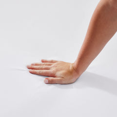 Woman's hand pressed down onto the mattress topper to display the responsive support of the foam