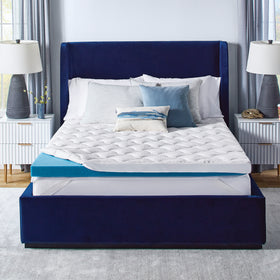 Novaform ComfortGrande Plus Advanced Mattress Topper placed on a mattress with the quilted cover slightly unzipped and pulled back to reveal one corner of the gel memory foam topper. 