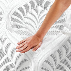 A woman places her hand on the quilted cover, feeling the cool touch fibers on the surface. 