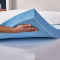 A closeup of a woman’s hand holding up the gel memory foam layer, showing how it is placed directly on top of a mattress. 