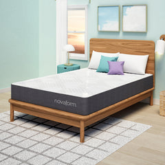 Angled view of the memory foam mattress complete with white, teal and purple pillows