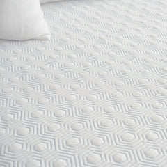 Close view of the topper's soft white slip cover with stress relieving Celiant technology woven into the patterned design