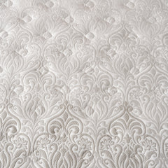 Close up view of the mattress cover with a gray and white with a fleur de lis style pattern and temperature regulating 37.5® fiber technology