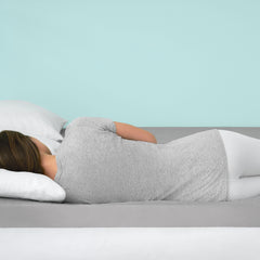 Young woman wearing athleisure lying on her side in perfect alignment on top of the foam topper