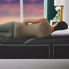 Young woman in athleisure lying on her side on the support foam mattress with her spine perfectly aligned
